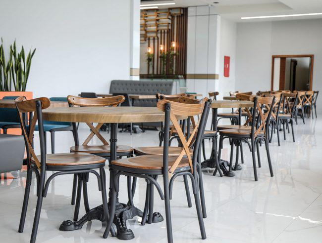 چیدمان میز رستورانی مدل ساران با پایه چدنی به همراه صندلی تونت کلاسیک با فریم فلزی مشکی و نشیمن چوبی – مناسب فضاهای کافی‌شاپ، رستوران و سالن غذاخوری